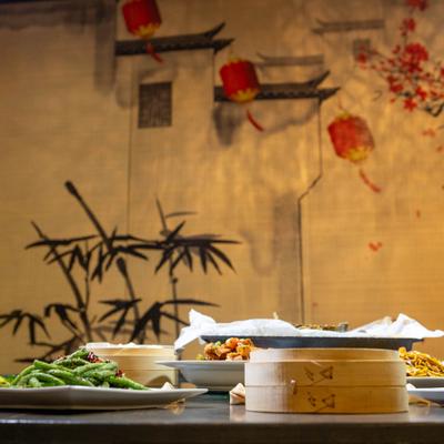 Assorted dishes and bamboo steamers on a table.