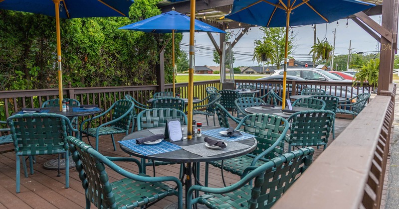 Exterior, tables and chairs under parasols and the pergola, wooden decking and railing