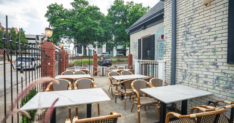 Exterior, marble top tables for four, concrete flooring, white brick establishment walls