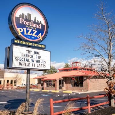 Pizzaeria's sign in front of the building.
