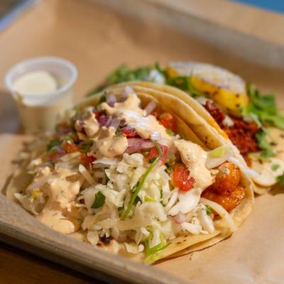 Shrimp tacos served with sour cream.