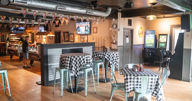 Interior, high tables with checkered tablecloths and chairs
