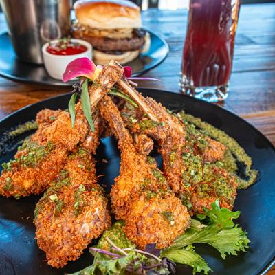 Fried lamb chops served with garnish and a cocktail