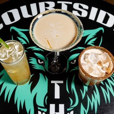 Assorted cocktails, placed on counter with Courtside logo, top view.