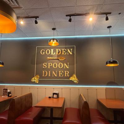Golden Spoon Diner interior with booth seating, warm lighting, and a decorative gold wall sign.