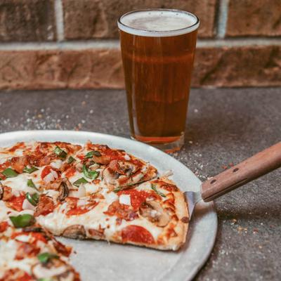 Supreme pizza served with a glass of beer.