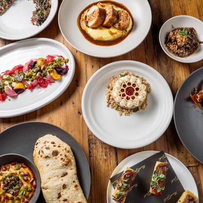 A variety of colorful dishes spread on a wooden table.