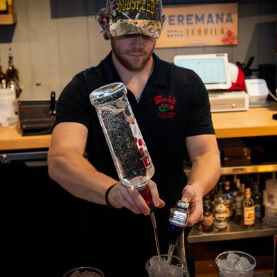 A person preparing a cocktail.