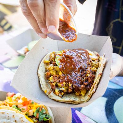 Mi Ranchita Taco being topped with sauce.