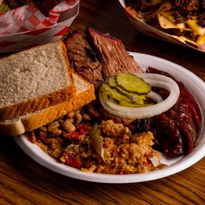BBQ meats, pickles, onion, rice, and beans served with toast bread.