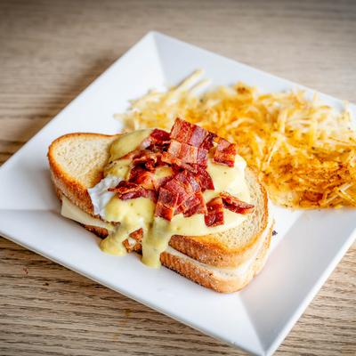 Grilled cheese and bacon Benedict served with shredded potatoes.
