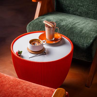 Crème brûlée and a warm beverage topped with a cookie served on a side table.