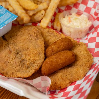 Fried catfish with hush puppies, crinkle cut fries, and coleslaw.