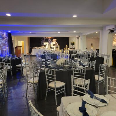 Elegant banquet hall with round tables and a decorated stage.