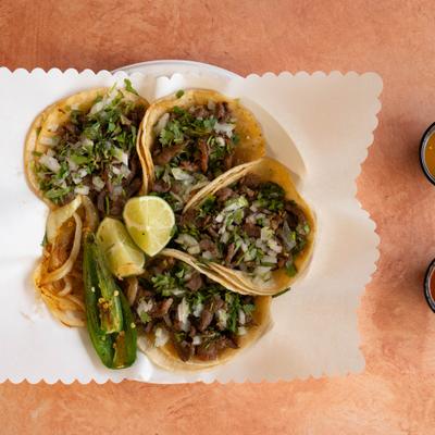 Steak tacos with onion and cilantro.