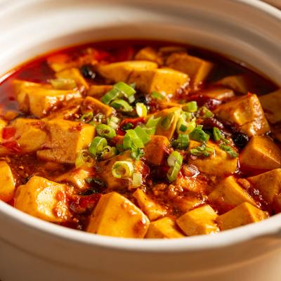 Mapo tofu with scallions in a pot.