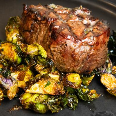 Filet mignon served with roasted brussels sprouts.