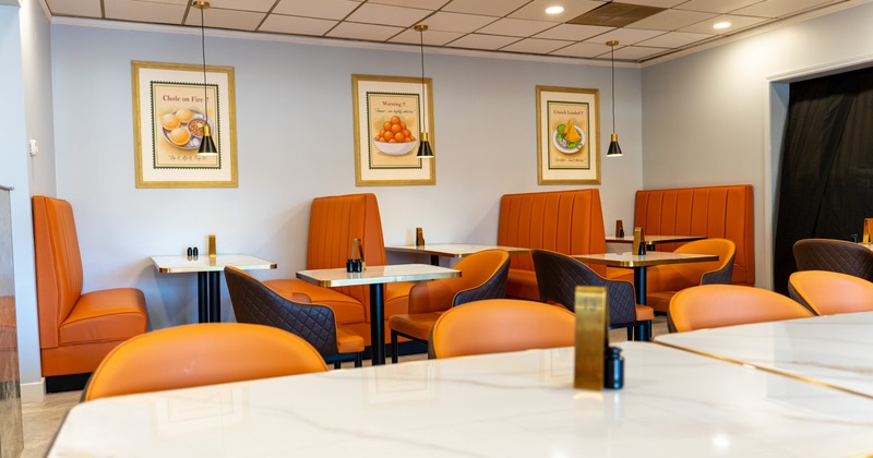 Seating space with booths and tables, art on the wall