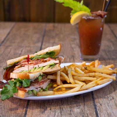Turkey and avocado sandwich served with fries on the side