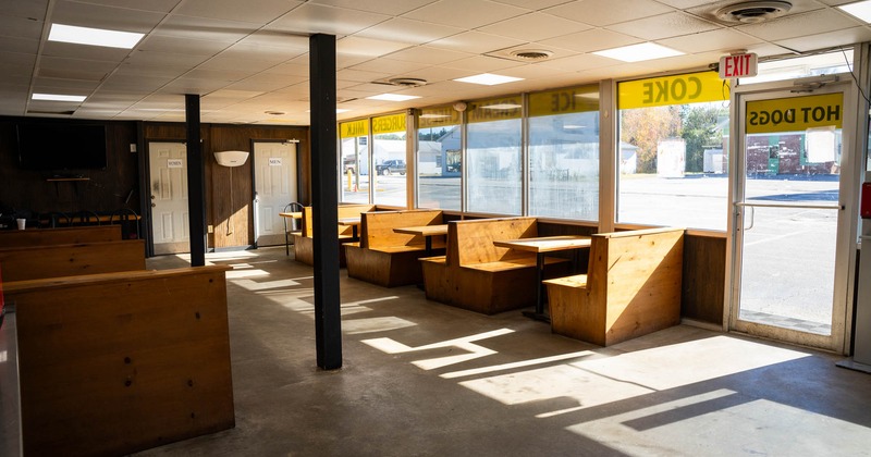 Interior, dining area, wooden seating booth benches with tables, entrance