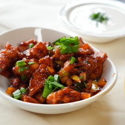 Chicken Manchurian garnished with diced green onion.