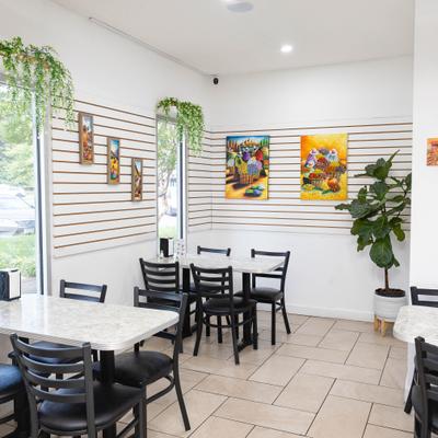 Bright restaurant dining area with colorful wall art.