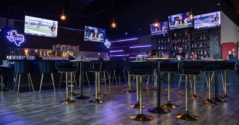 Interior, high seating area, padded stools with high tables, bar in the back