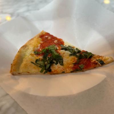 A slice of Margherita pizza on a plate.