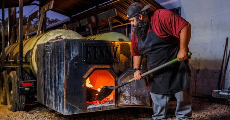 Employee shoveling wood in the furnace