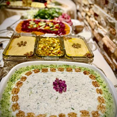 Persian appetizer buffet with yogurt dip and colorful salads.