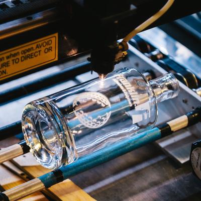 A bottle in an engraving machine.