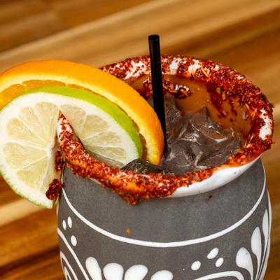 Tajin rimmed cocktail in a clay mug.
