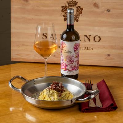 Pasta carbonara topped with guanciale, paired with rose wine.