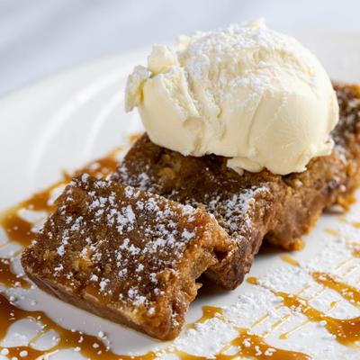 Sticky bread pudding on top of Carmel syrup with vanilla ice cream.
