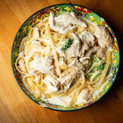 Fettucine chicken Alfredo served on a colorful plate.