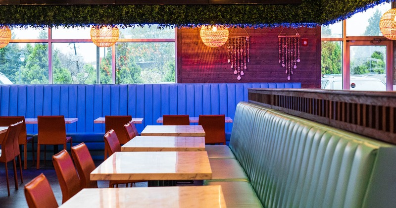 Interior, tables, upholstered benches, chairs, windows, decorations, lighting