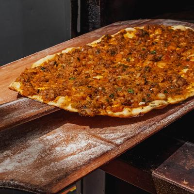 Pizza from scratch on a pizza peel.