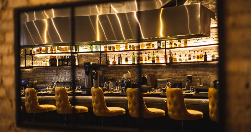 Bar and comfortable bar stools as a reflection in the mirror