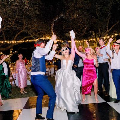 The bride, groom, and guests dancing on the dance floor.