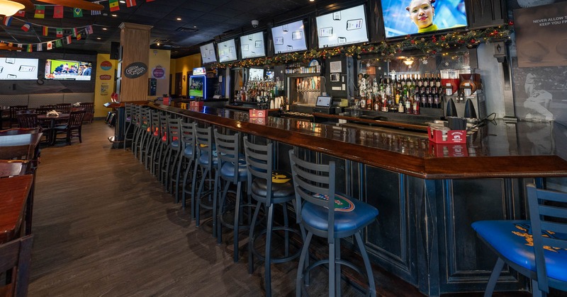 Bar area with barstools and TV screens