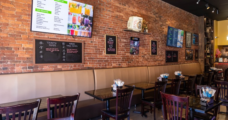 Interior, tables and chairs all lined up with pictures on the wall