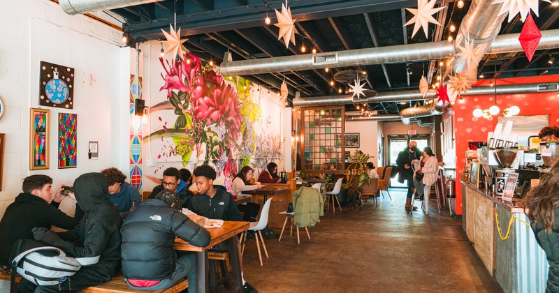 Interior, bright and eclectic dining area, tables and chairs, decor on the walls