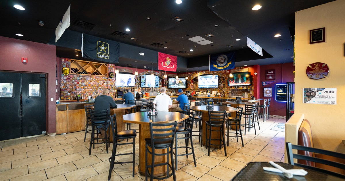 Interior, bar area, stools, tables, bar and tv screens behind