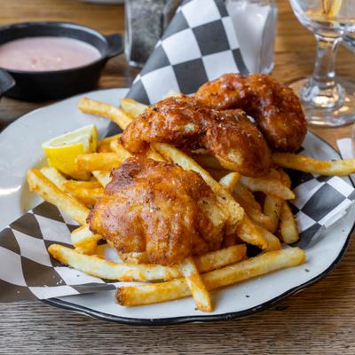 Fish and Chips served on a plate lined with black and white checkered paper.