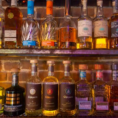 Lined up bottles of tequila on bar shelves