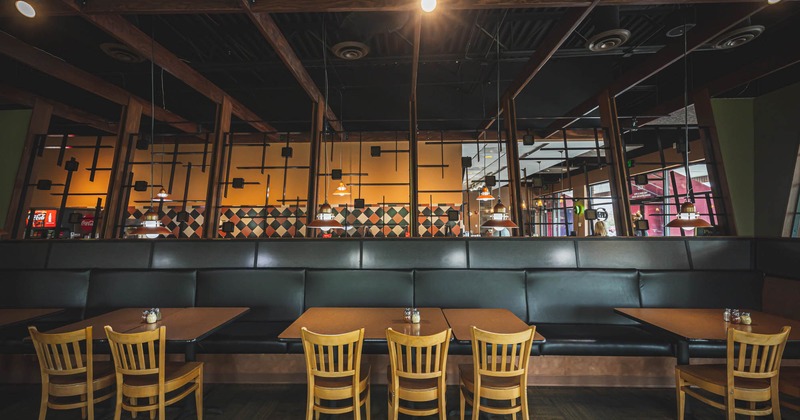 Interior, tables with banquette seating and chairs ready for guests