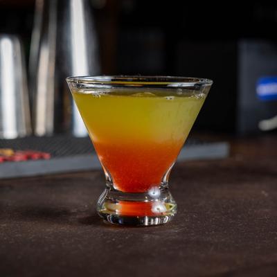 All Shook Up cocktail served in a cosmopolitan glass on a bar counter, side view.