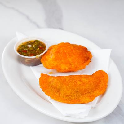 Fried empanadas with a sauce for dipping.