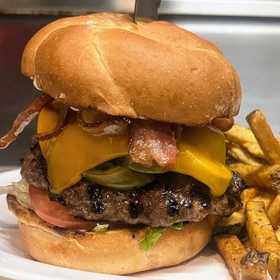 A served bacon burger with fries.