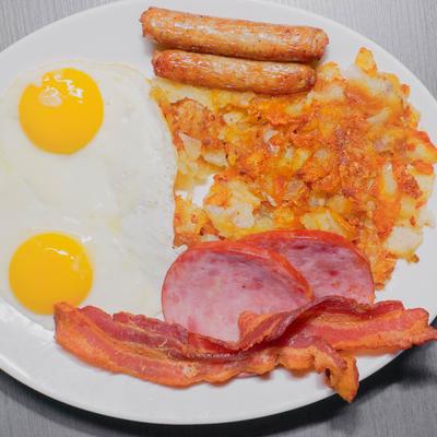 Breakfast platter, with sunny side up eggs, sausages, bacon, Canadian bacon, and hash browns.